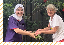 Photo of Sahar (left) helping client with gardening